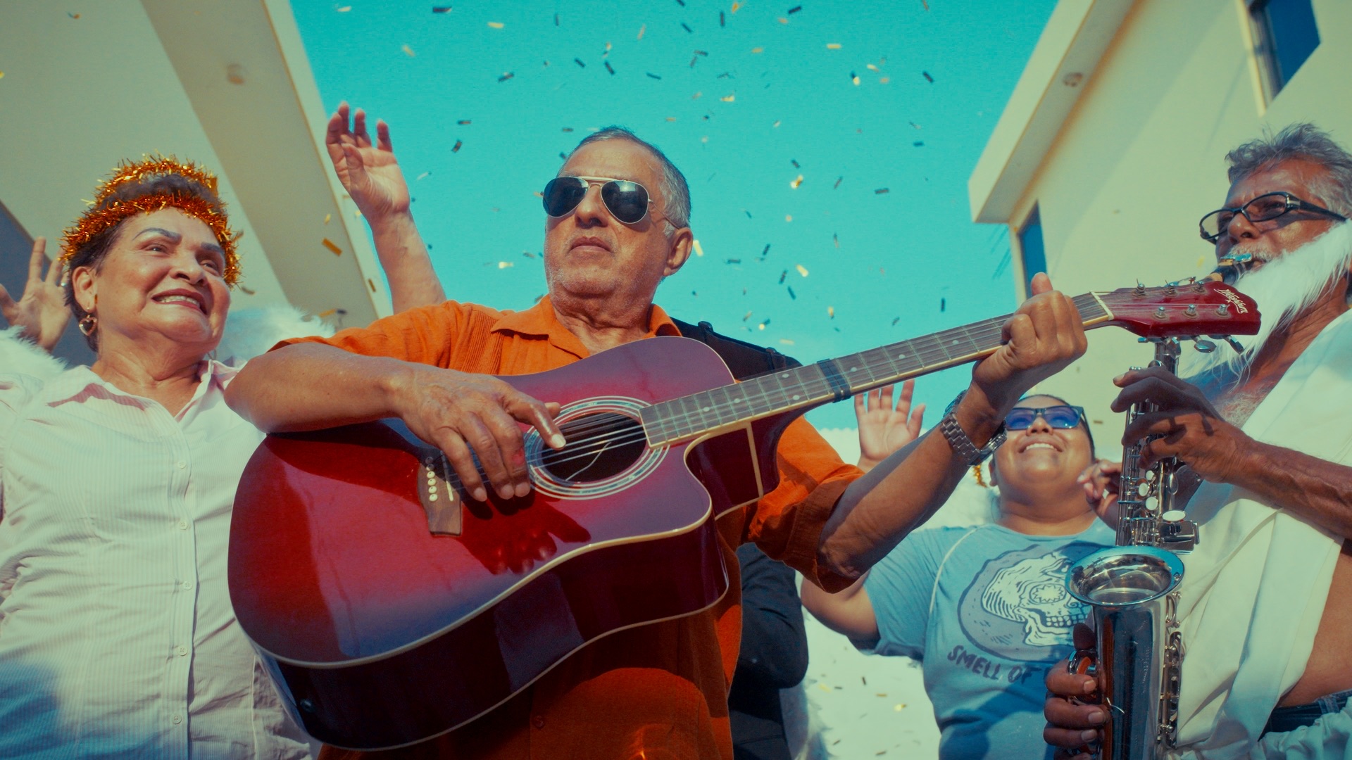 Fotograma de Motel Paraíso: un hombre toca la guitarra durante una celebración familiar